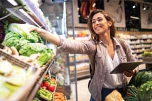 woman picking produce at grocery store